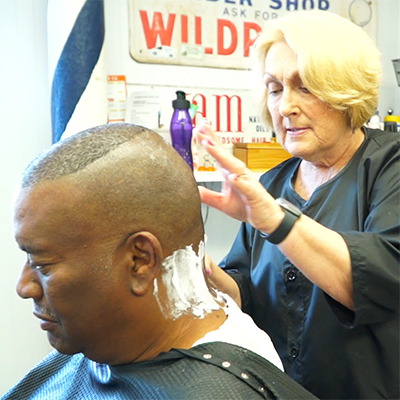 Stylist shaving a clients head at Third Street Barbershop, Wytheville, VA